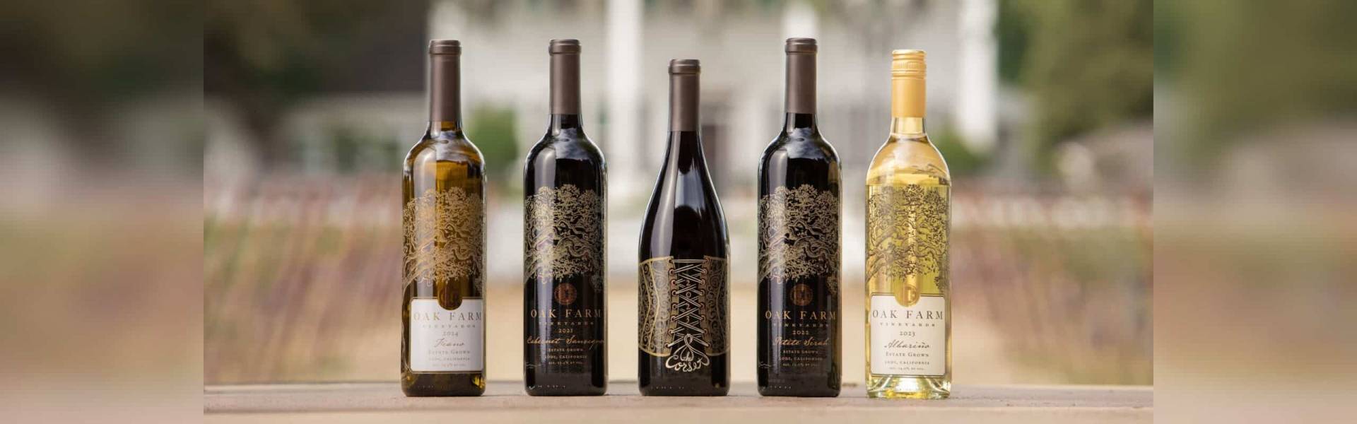 Oak Farm Vineyards estate wines lined up in front of the farmhouse